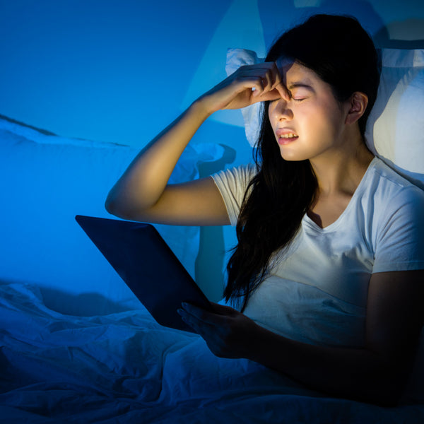 Tired woman in bed still using computer screen