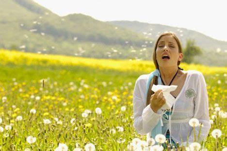 woman sneezing in a field of flowers