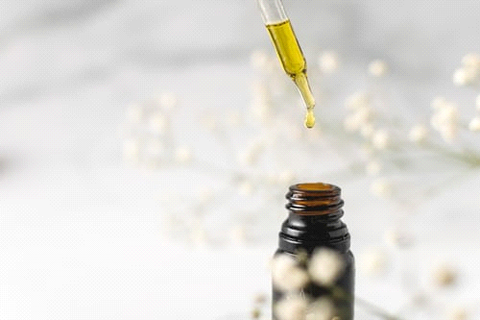 Taking CBD oil from a bottle using a dropper