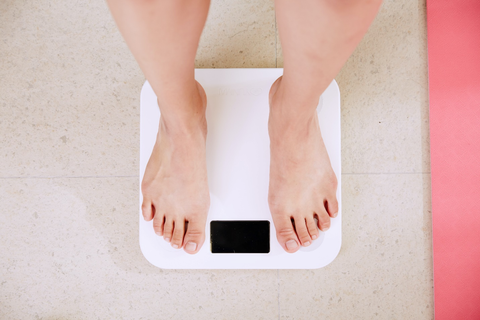 A person standing on the weighing machine.