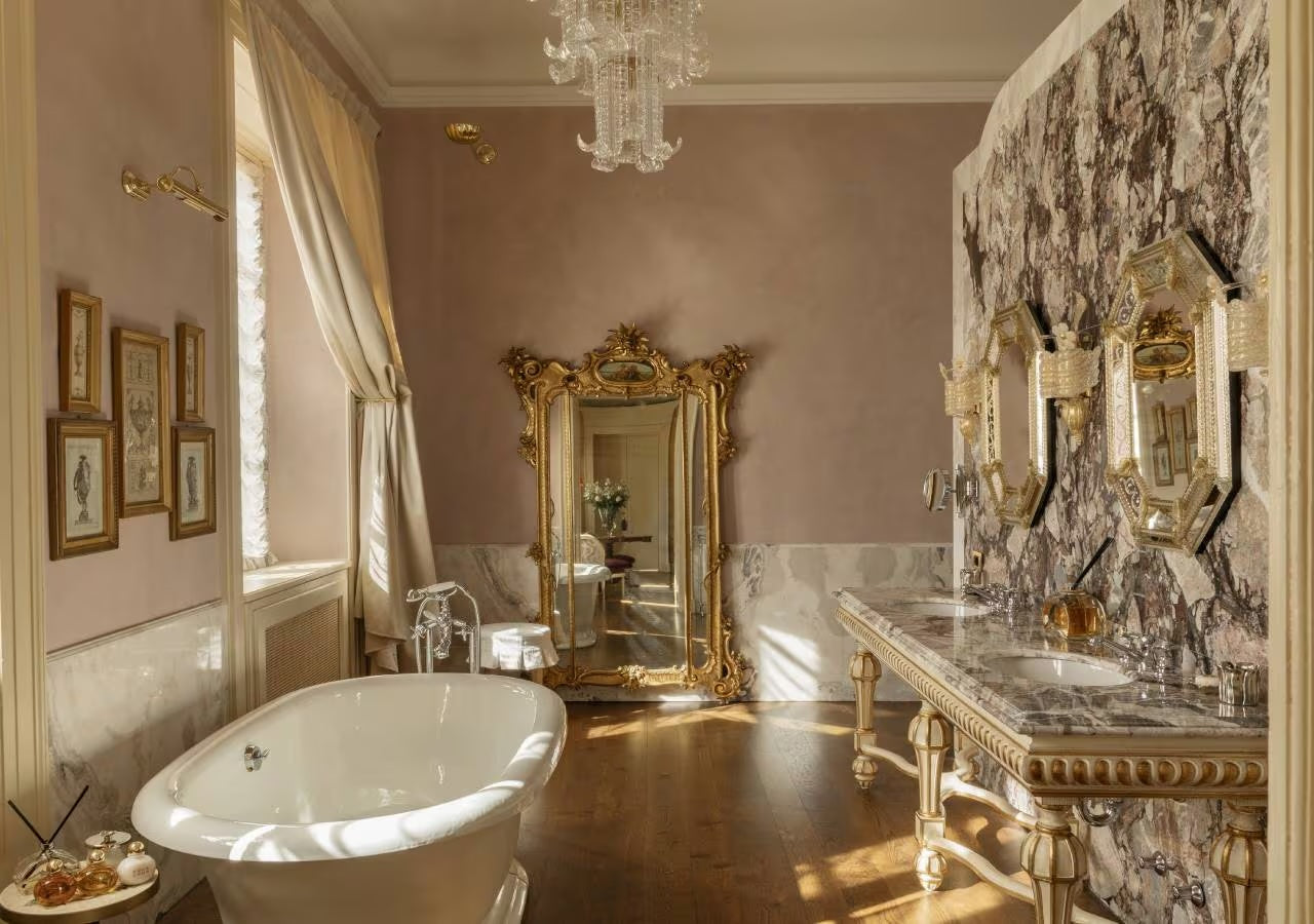 hotel bathroom with gold mirror and clawfoot bath