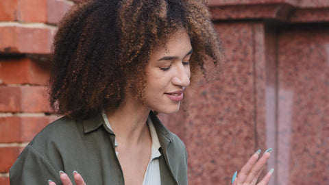 confident young woman with natural hair deep in thought