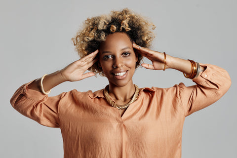 African American woman with color treated natural hair massaging her scalp