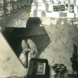 Mayday Signals by Swell Maps on Easy Action Records (the album cover is black and white collage; the main image is of a cockatiel perched above a clock, looking into a mirror).