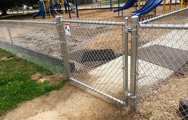 Photograph of galvanized chain link fence protecting a playground.