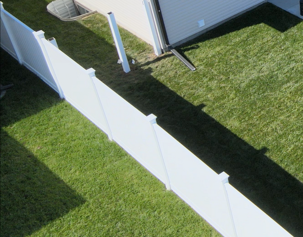 Aerial view of a white vinyl fence in a residential neighborhood.