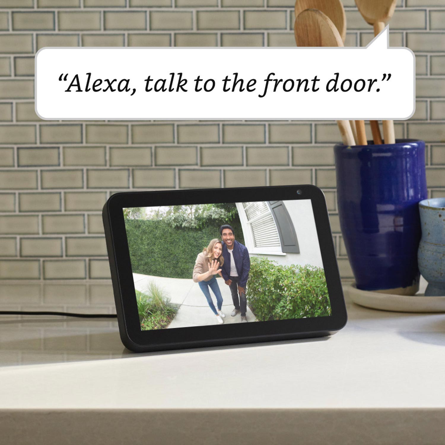 Video Doorbell Wired - On a kitchen countertop, an Echo Show 5 shows 2 people looking into camera of Video Doorbell. Text reads: 