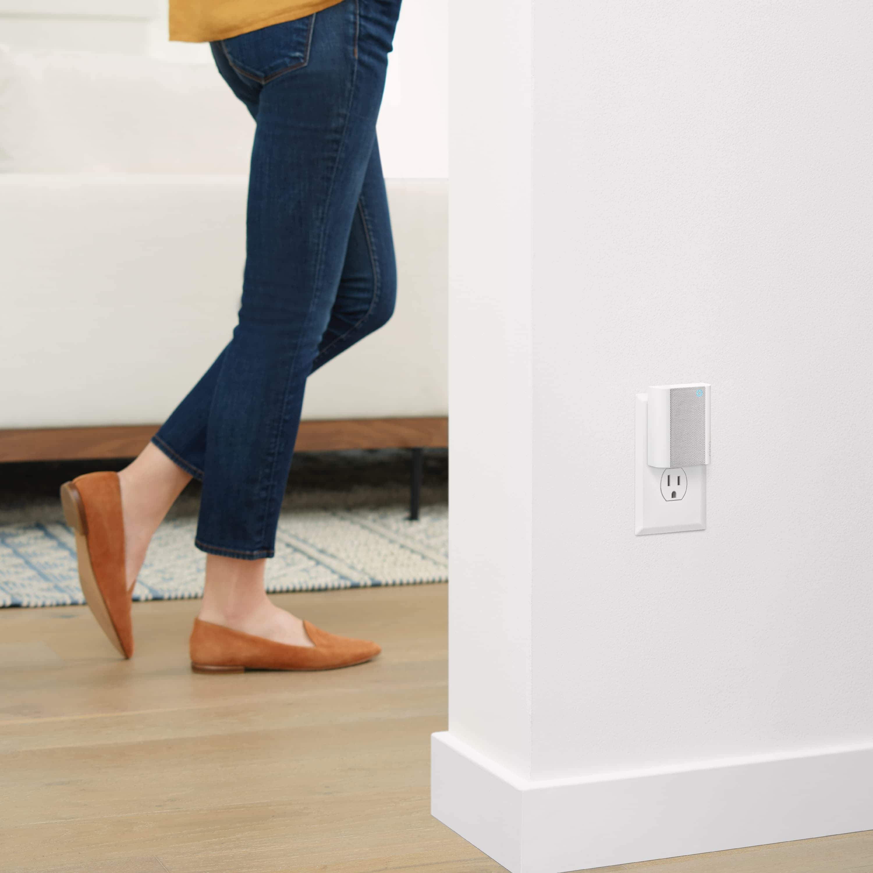 Chime - Chime: Ring Chime plugged into wall outlet with a person walking by in the background.