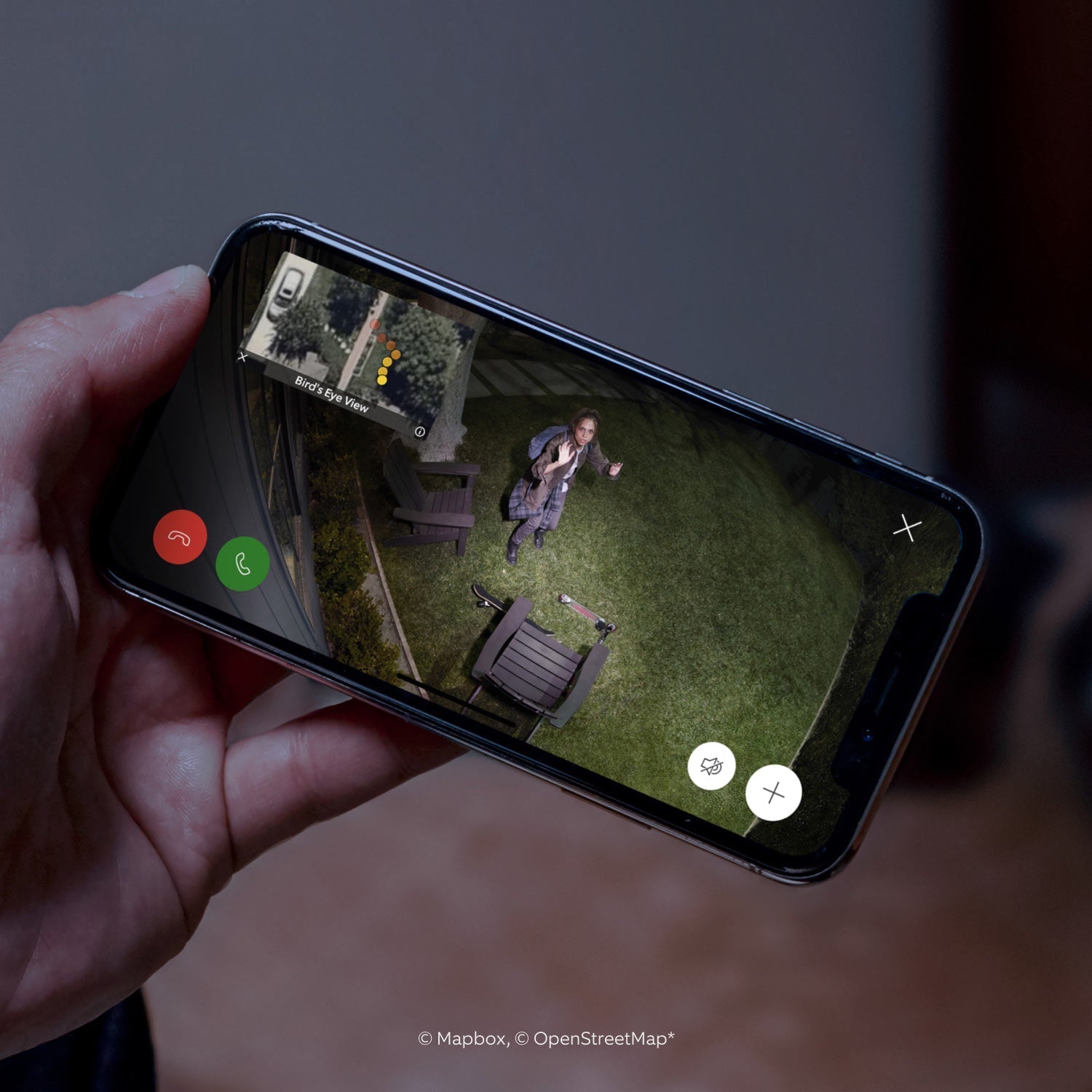 Spotlight Cam Pro (Wired) - Close-up of smartphone showing video of a person in a yard, looking up into Spotlight Cam Pro camera. Inset is bird's eye view perspective.