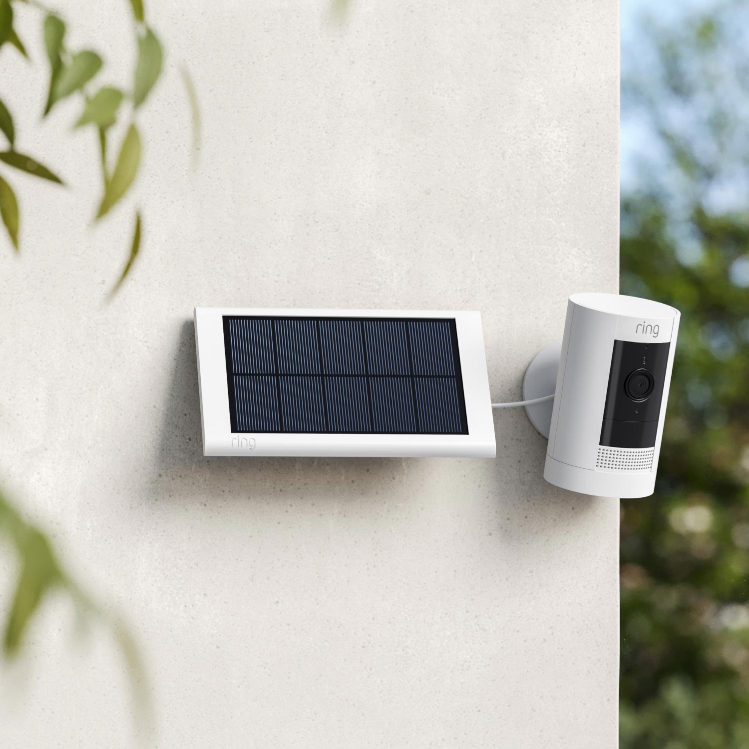 Stick Up Cam Solar - Stick Up Cam and small solar panel, both in white, mounted to outside corner of house.