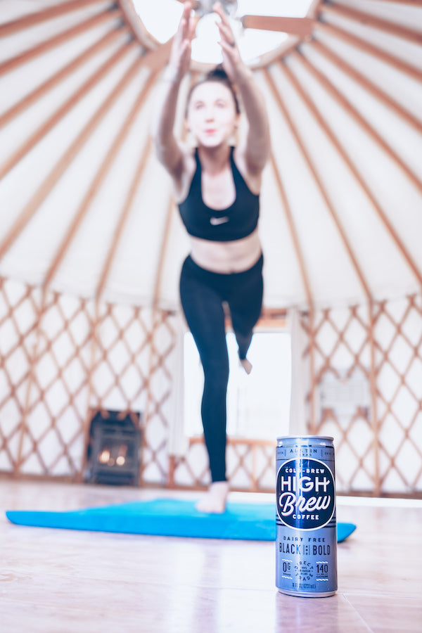 Woman doing yoga with a high brew cold brew can