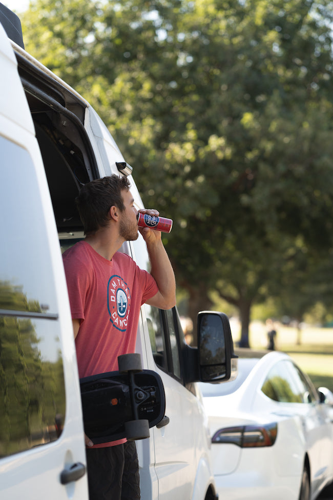 Man drinking High Brew in a van