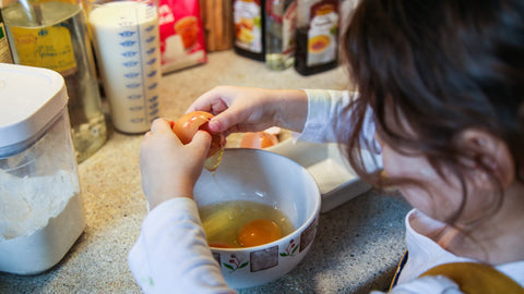 Jojo casse les oeufs pour la préparation de la pâte à crêpes