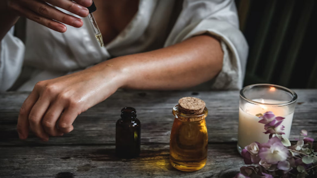 A woman putting emu oil on her arm with a dropper.