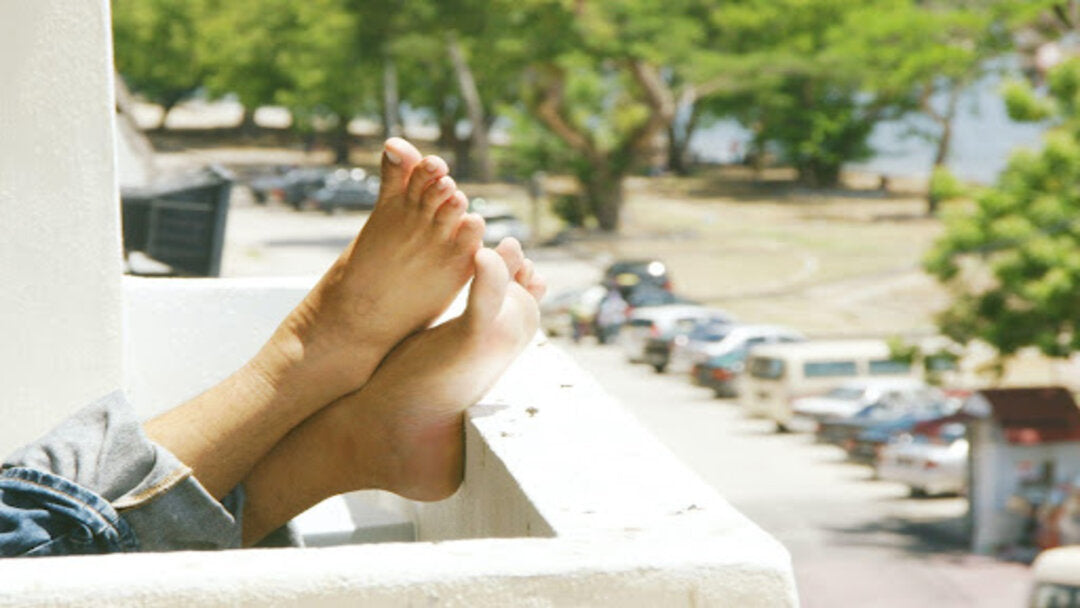 Person's bare feet up on a balcony