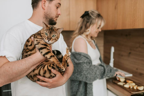 Man holding cat in the kitchen