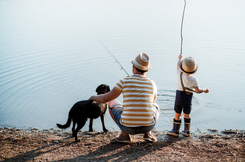 son and dad fishing with dog