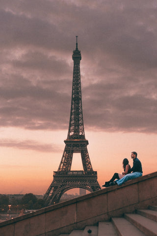 Couple sitting near the Eiffel tower in Paris