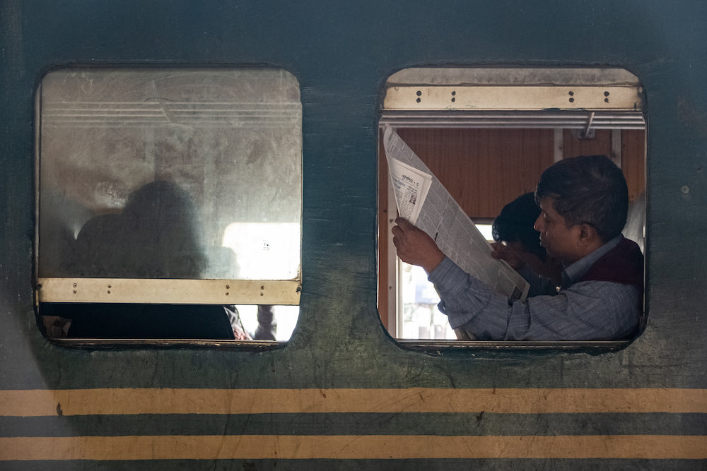 Reading a newspaper on a train 