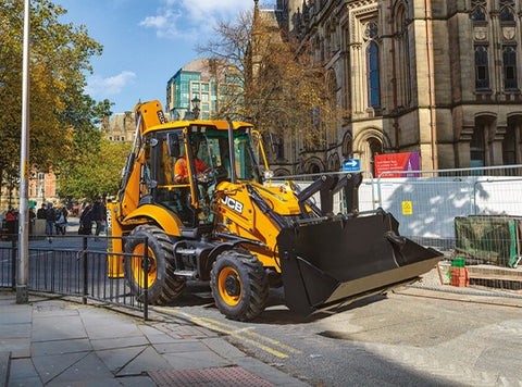JCB 3CX backhoe loader driving around the city streets