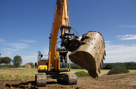 Hill Tefra tilting hitch mounted to a digger and fitted with a digging bucket