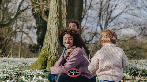 A mother and her two children in a Garden by a tree