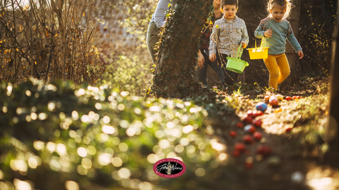 Two children partaking in an Easter Egg hunt in a forest