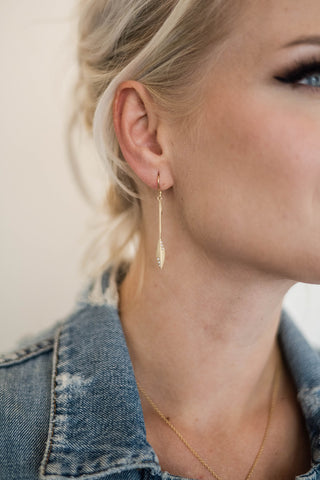 woman in denim jacket wearing stiletto gold and diamond earrings Nikki Lorenz Designs