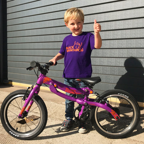 Boy with SKOG bike giving thumbs up