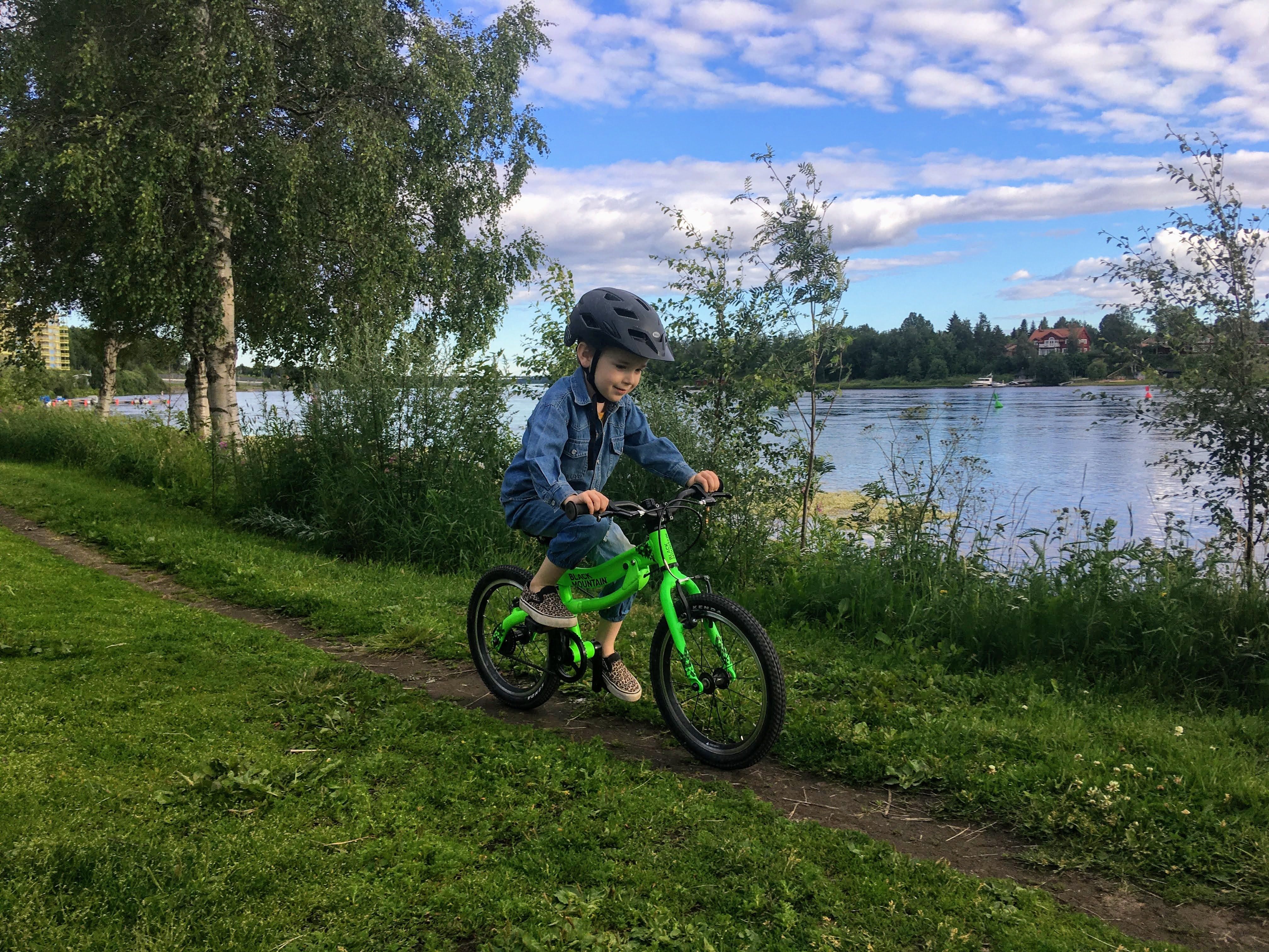  Child on kids bike riding by lake