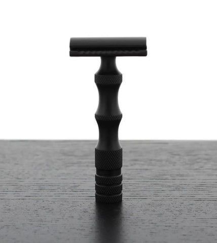 Black Safety razor standing upright on black table
