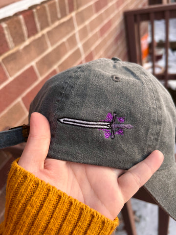 An updated embroidery sample of a sword on the side of a hat.