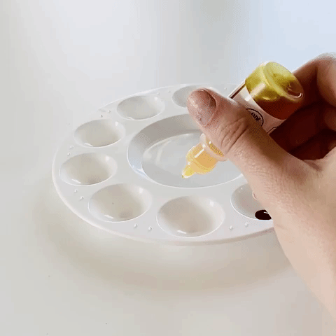 small clip of two single drops being squeezed out of paint bottle