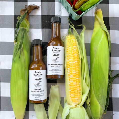 Umami everyday sauce and smoked jalapeño hot sauce on grilled corn on the cob vegan barbecue