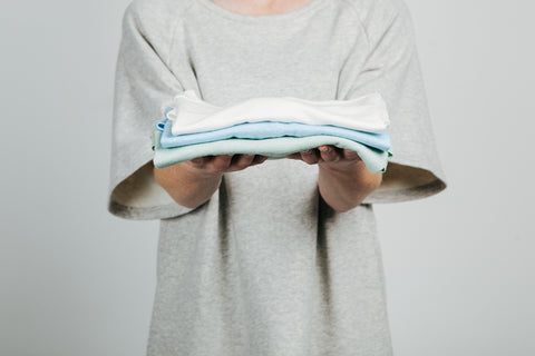Raglan luxe pullover holding folded linen tshirts