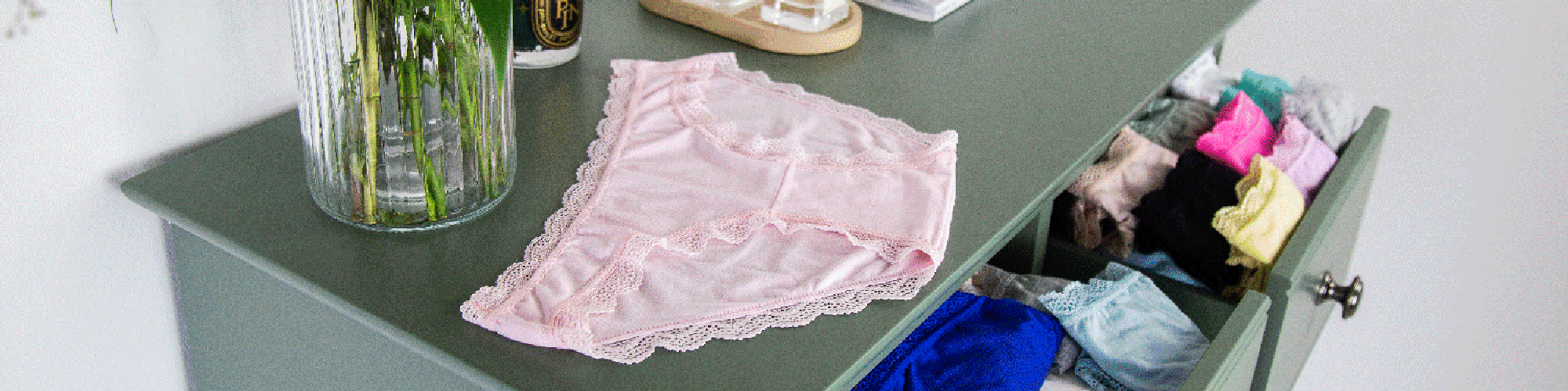 Knickers being folded on top of a chest of drawers