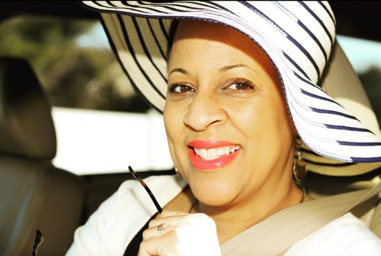 Dee Dean portrait smiling woman wearing black and white striped hat