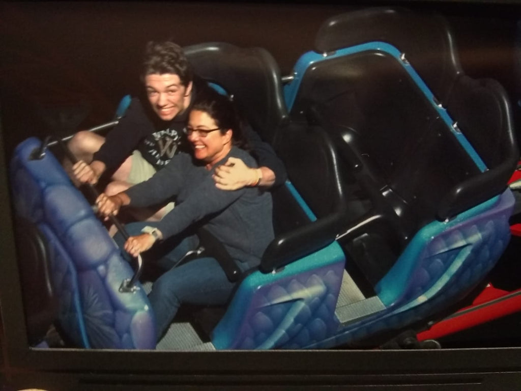 Woman wearing the silver Embr Wave 1 and man smiling in front seat of moving roller coaster car.