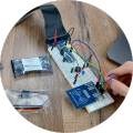 Hand working on breadboard circuit with RFID reader