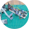 Breadboard circuit with Raspberry Pi camera on green engineering mat