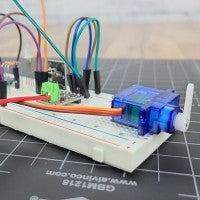 Breadboard circuit with servo on grey engineering mat