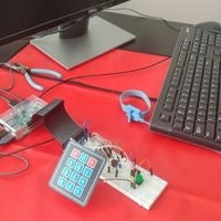 Breadboard circuit with keypad sitting next to keyboard and monitor