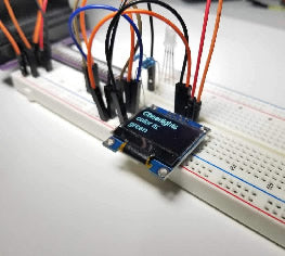 Breadboard circuit featuring OLED screen and jumper wires