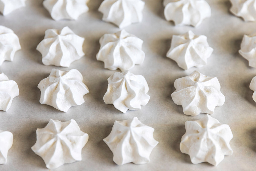 Rows of meringue on parchment paper