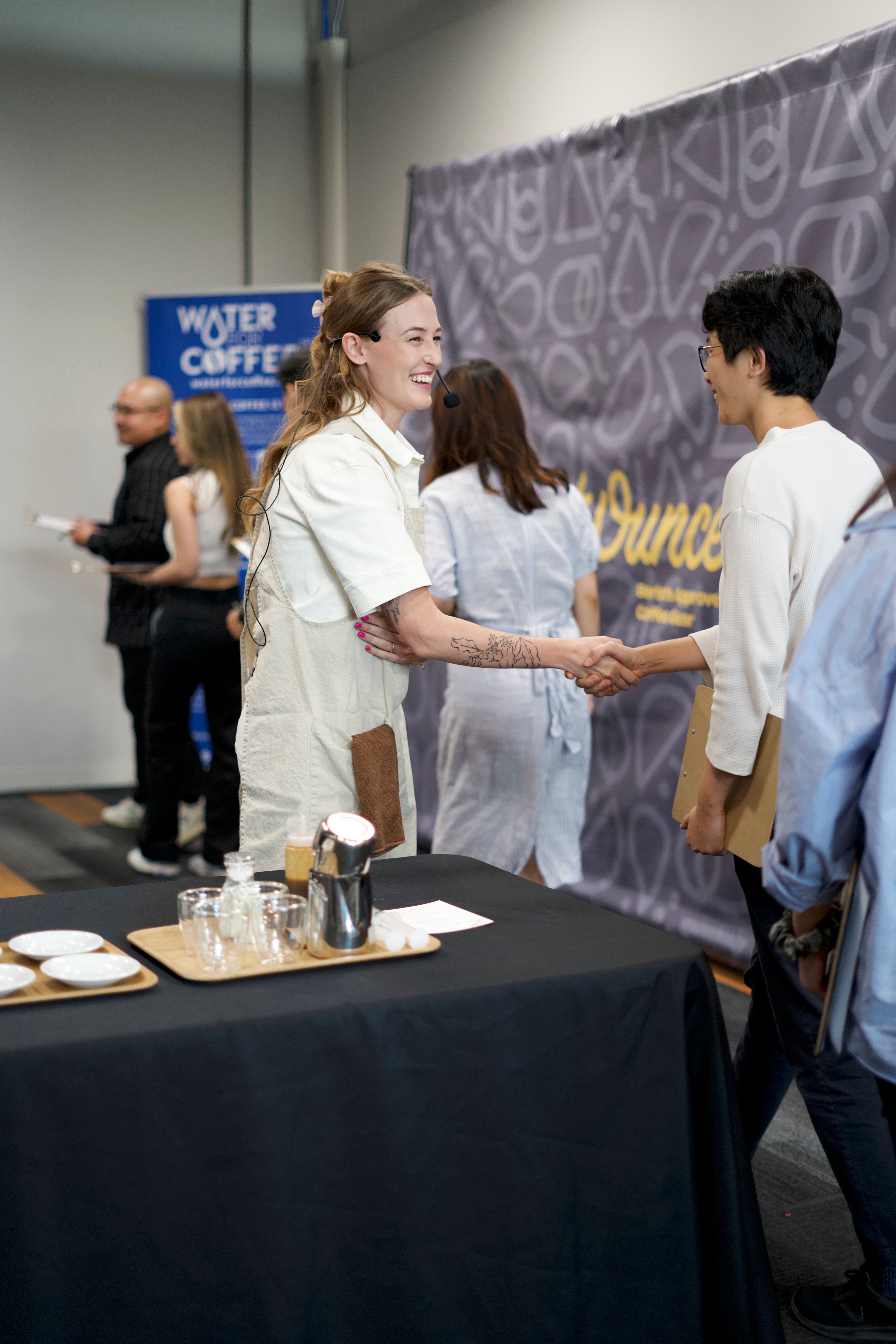 A woman in beige shaking hand with another woman in the SCA Q2 competition