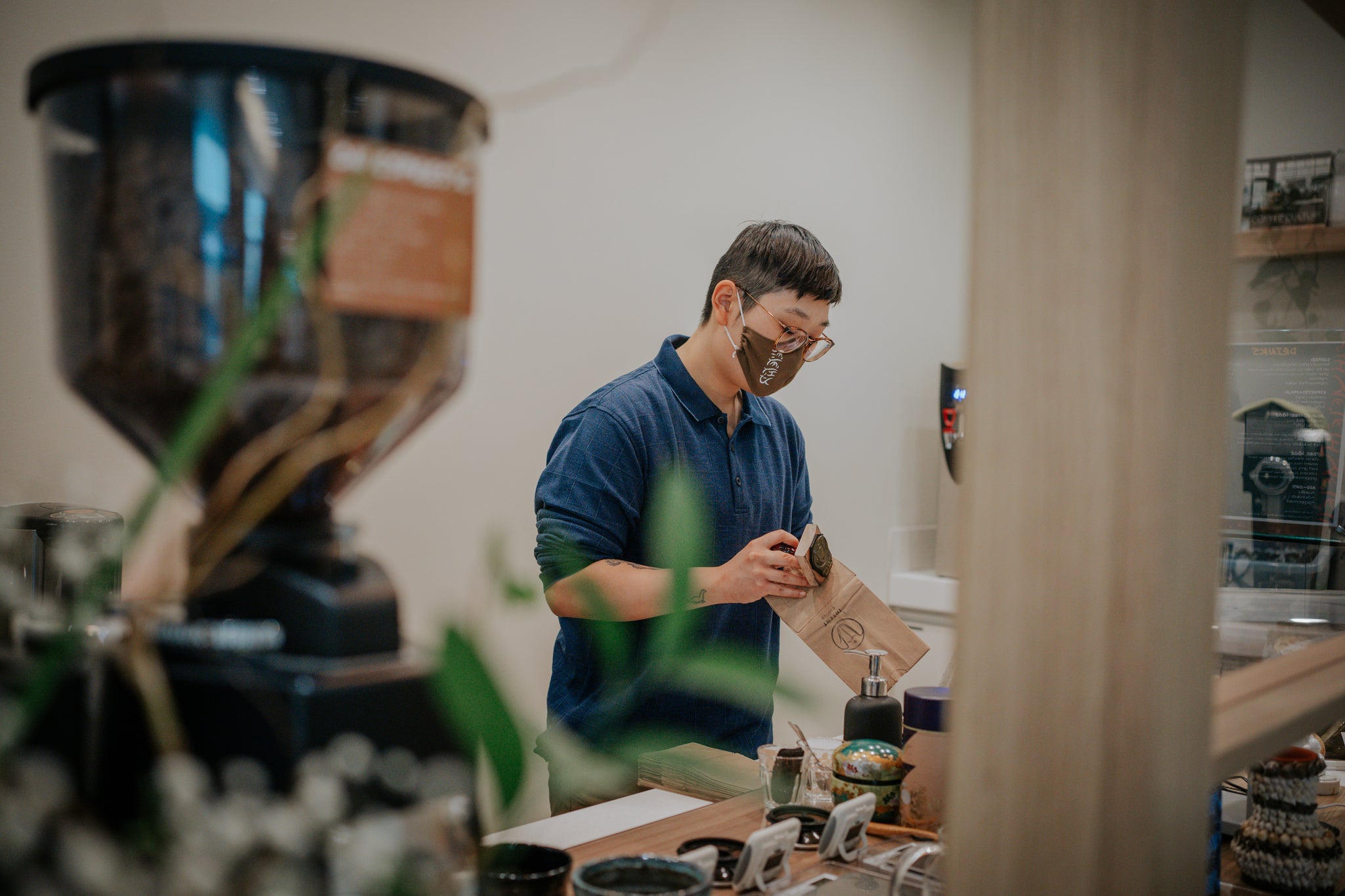 Ashley stamping paper bags with Intent Coffee logo