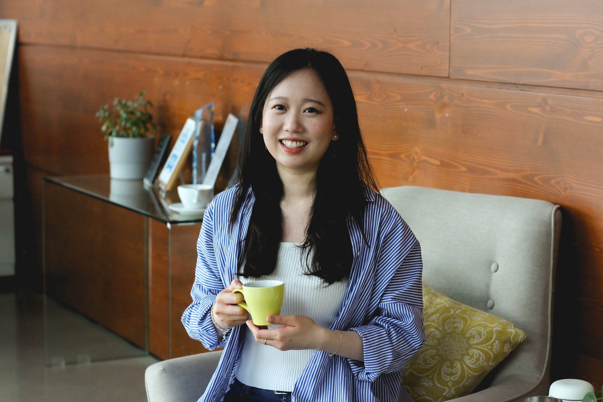 Jenny Tan sitting with a cup of coffee in the Eight Ounce Showroom