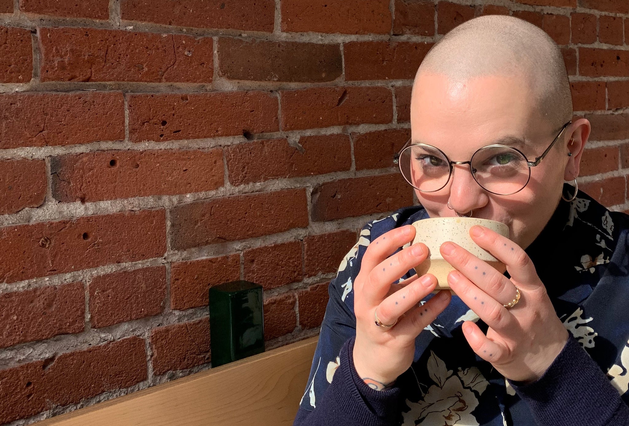 Catherine Gauthier taking a sip of coffee from a speckled beige cup