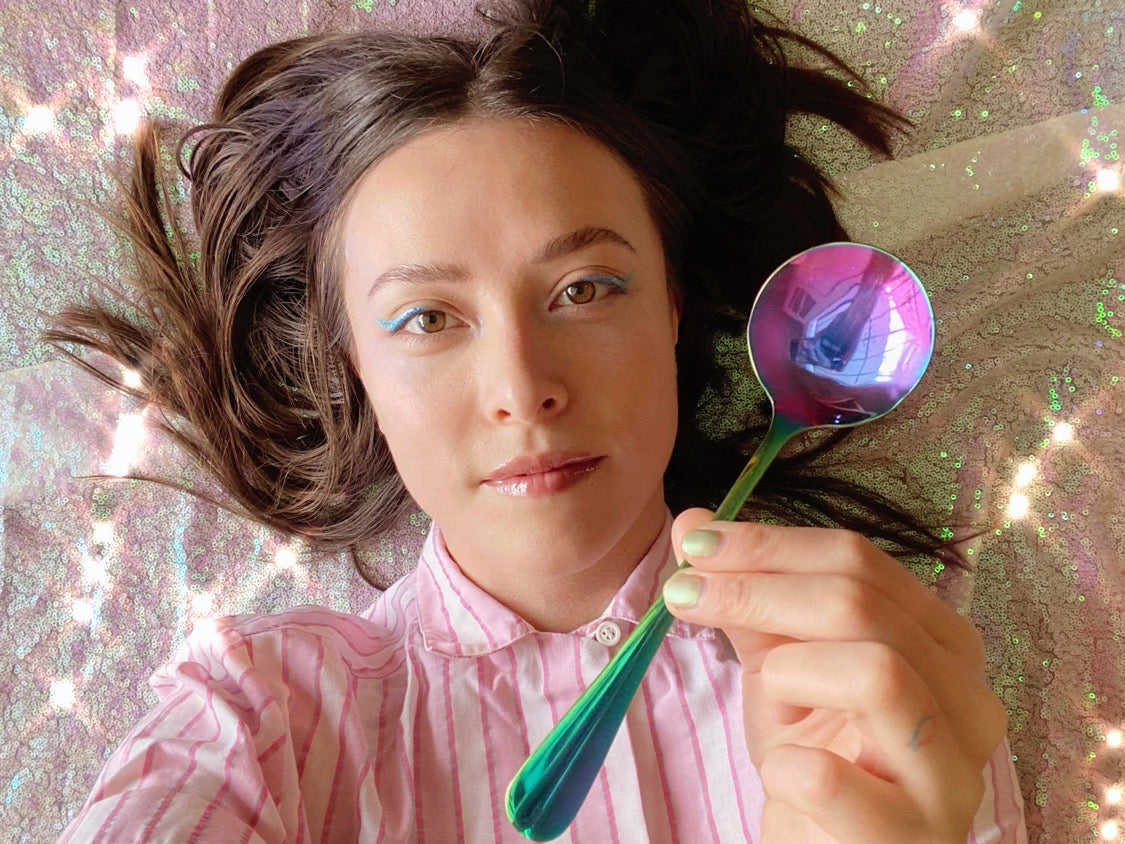 Umeko Motoyoshi holding an Umeshiso rainbow cupping spoon against a sparkling sequin background