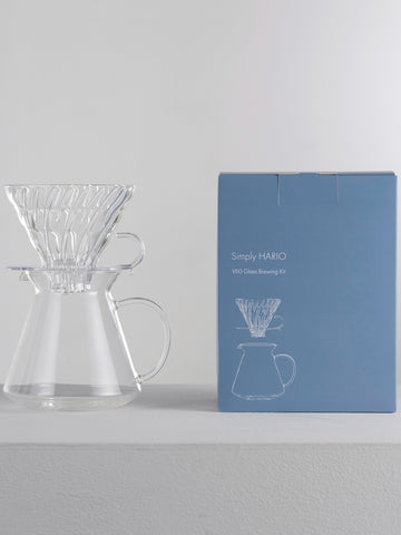 A Hario Simply Glass Brewing Set sitting next to it's blue box.